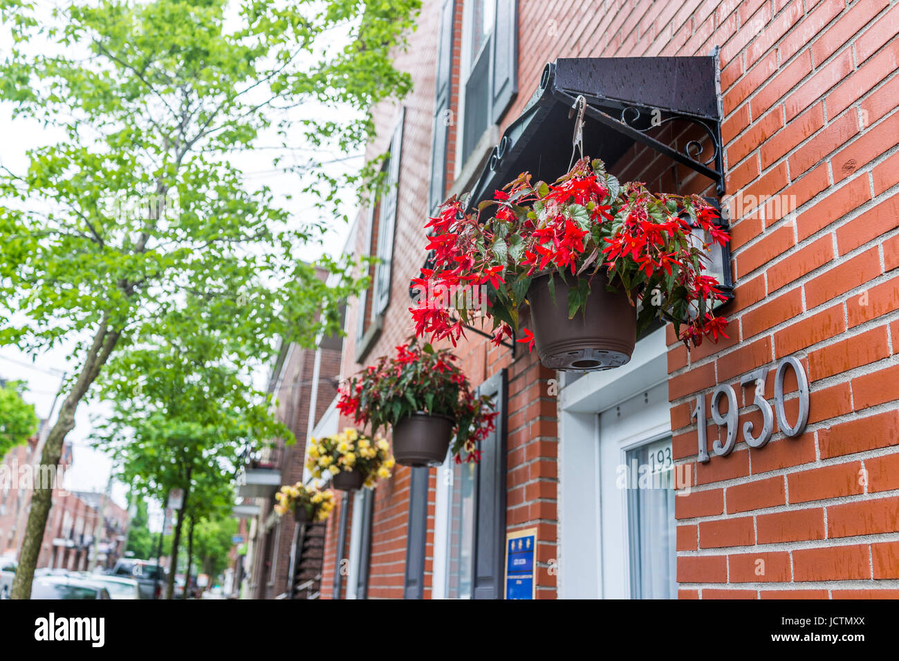 Montreal, Kanada - 26. Mai 2017: Hängende rote Blumentöpfe auf Backsteinbau im Stadtgebiet Stockfoto