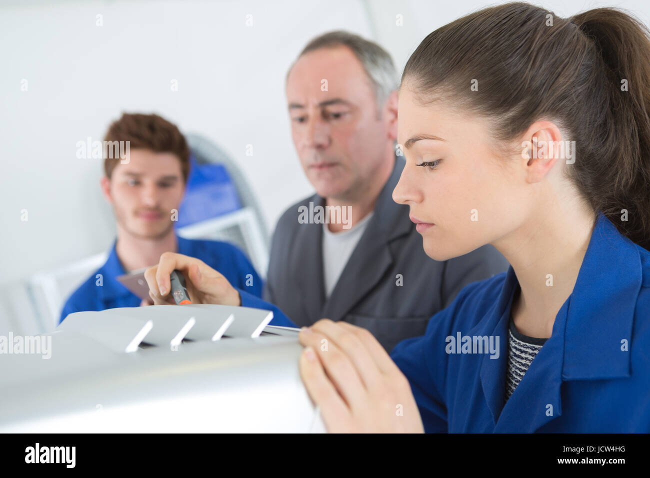 eine Klimaanlage Reparatur Lehrling behebt eine industrielle Kompressoreinheit Stockfoto