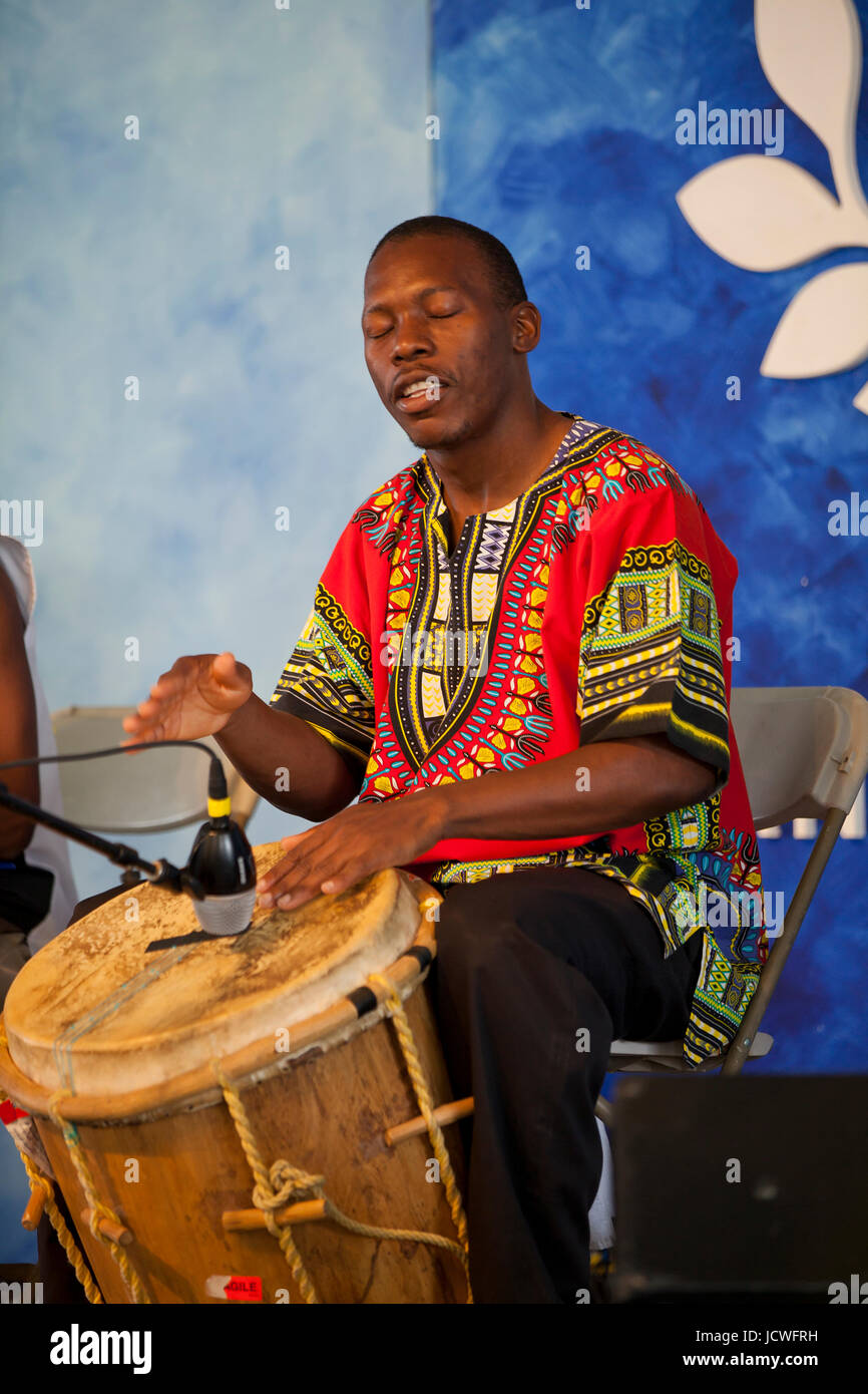 Afrikanischer Mann spielt traditionelle afrikanische Trommel auf der Bühne - USA Stockfoto