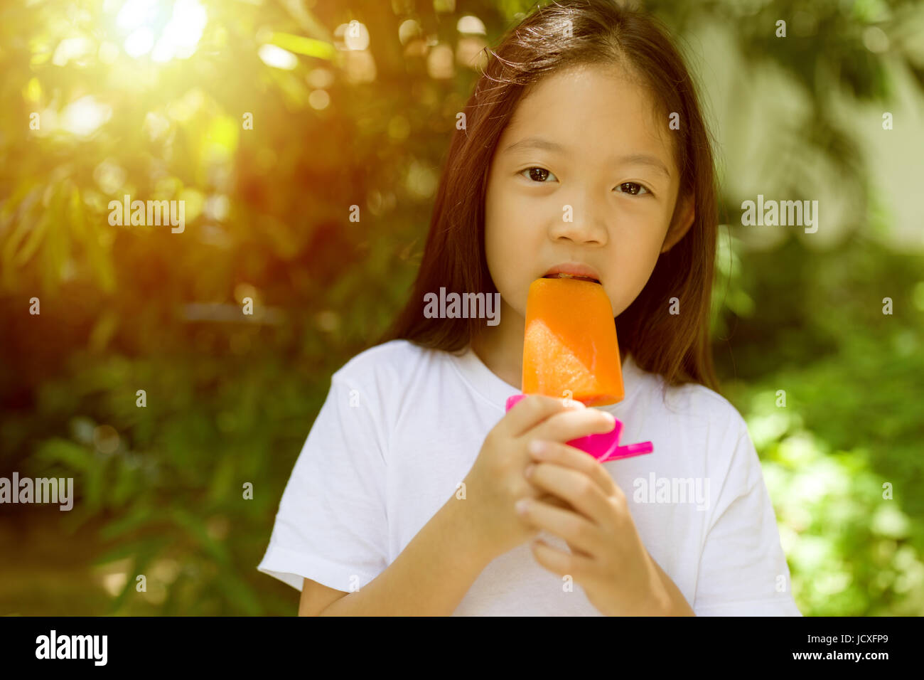 Glückliches asiatischen Kind essen Eis am Stiel-Eis an heißen Sommertag. Stockfoto