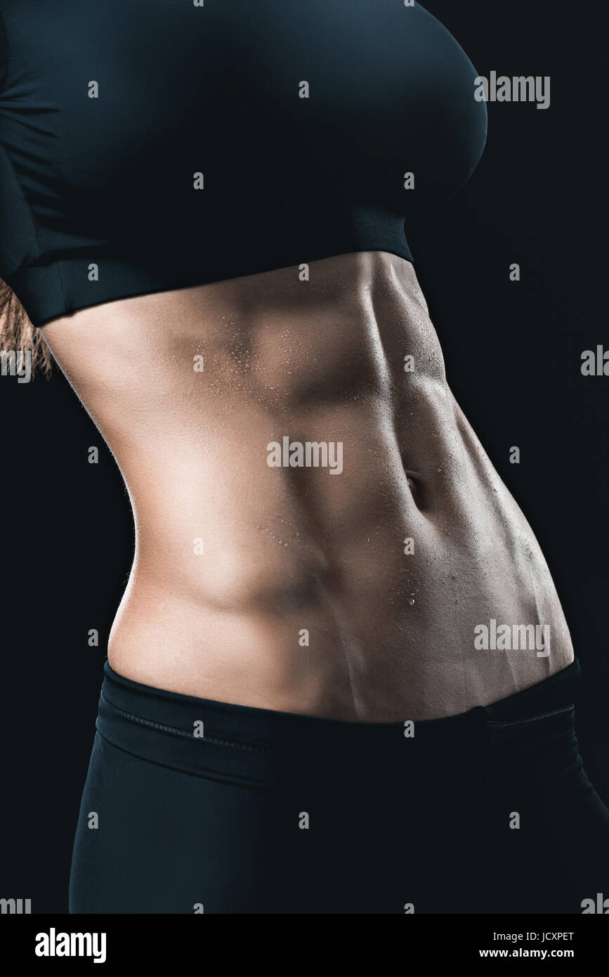muskulöse Frauenkörper mit abs isoliert auf schwarz. Sport-Konzept Stockfoto
