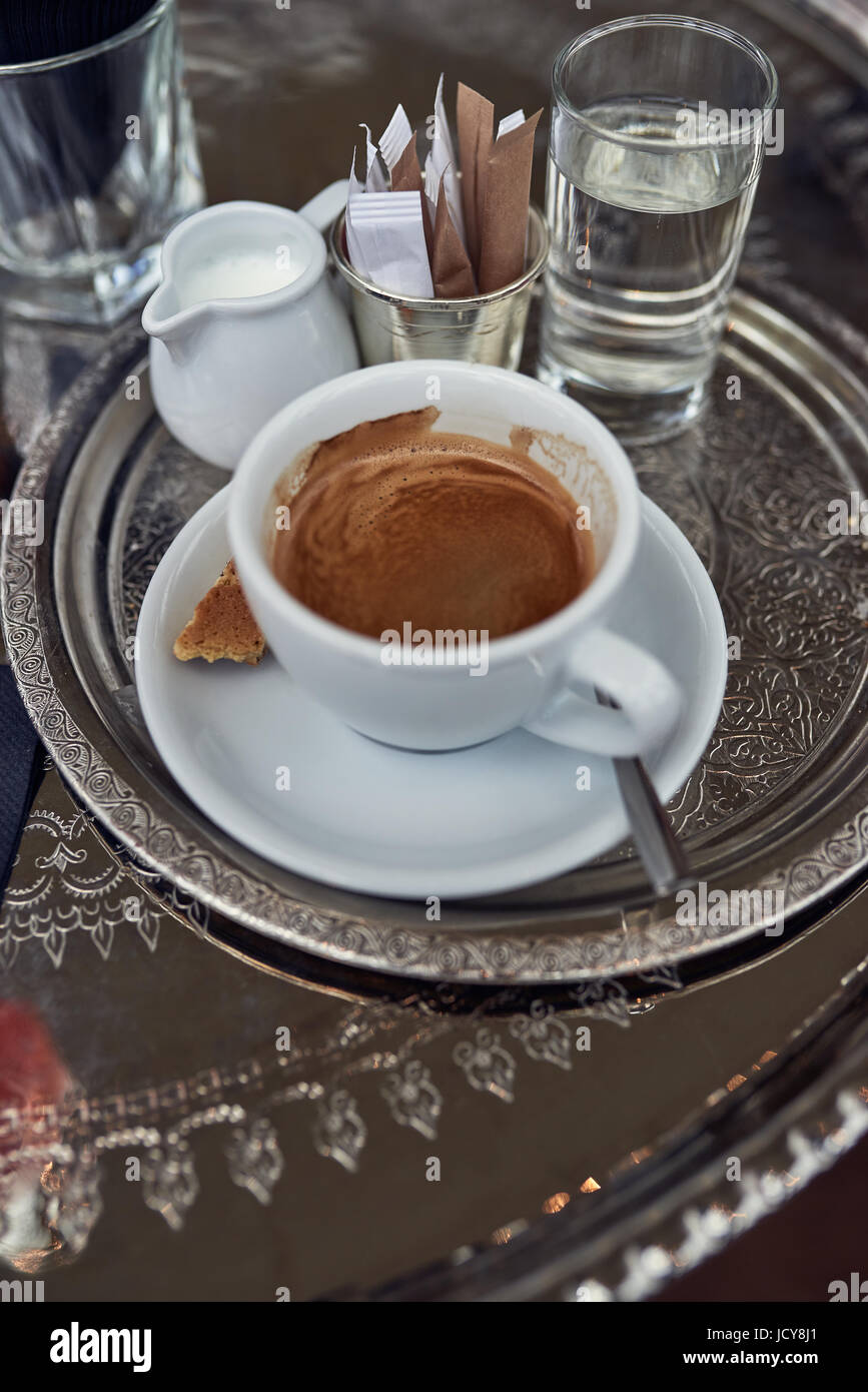 Starken Espresso Kaffee mit Milch in einen Krug und ein Glas Wasser auf  einem Tablett in einem Restaurant auf der Seite betrachtet nahe hohen  Winkel Stockfotografie - Alamy