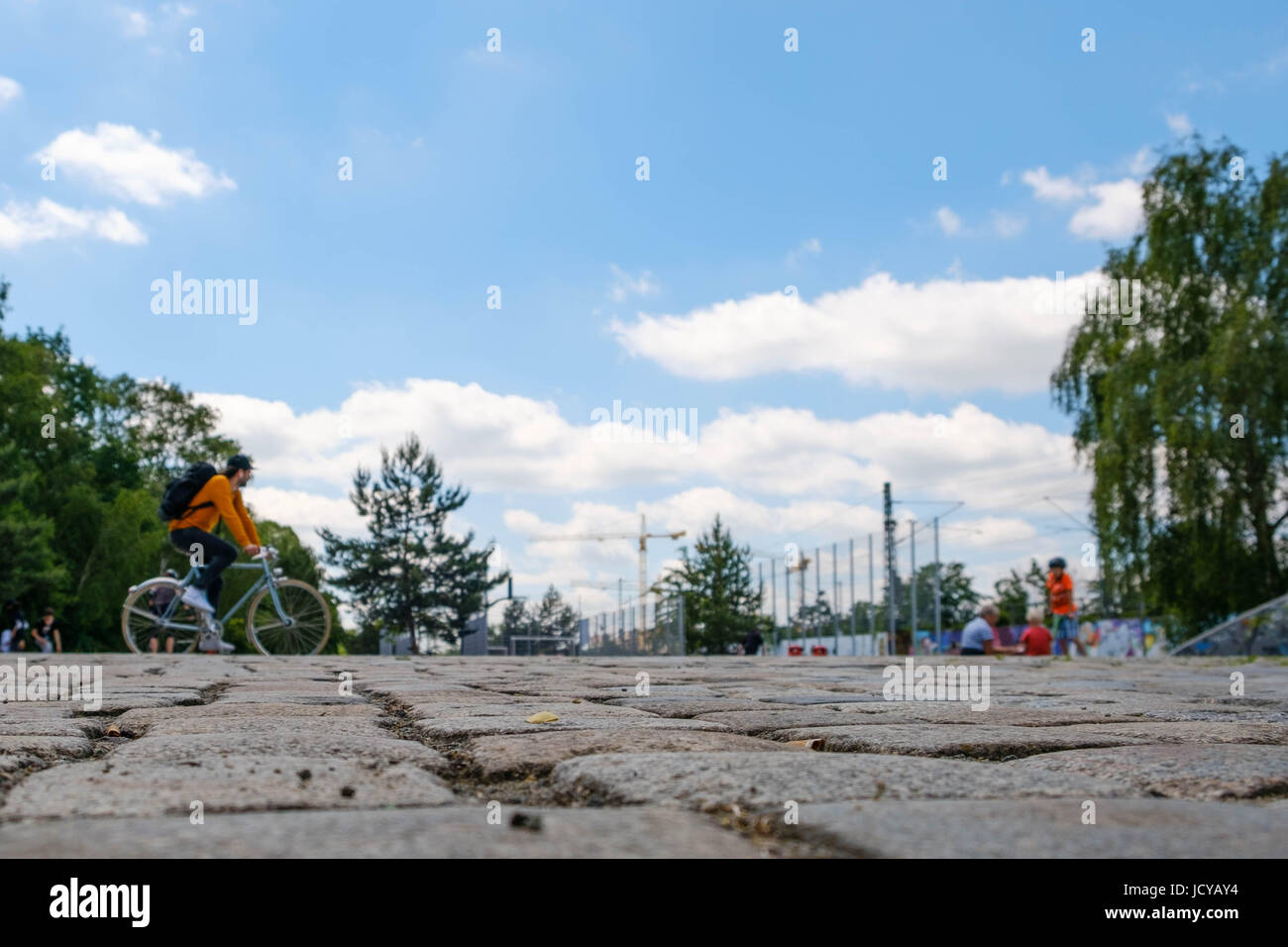 Kopfsteinpflaster Stein Closeup mit Menschen im Park und blauen Himmelshintergrund Stockfoto