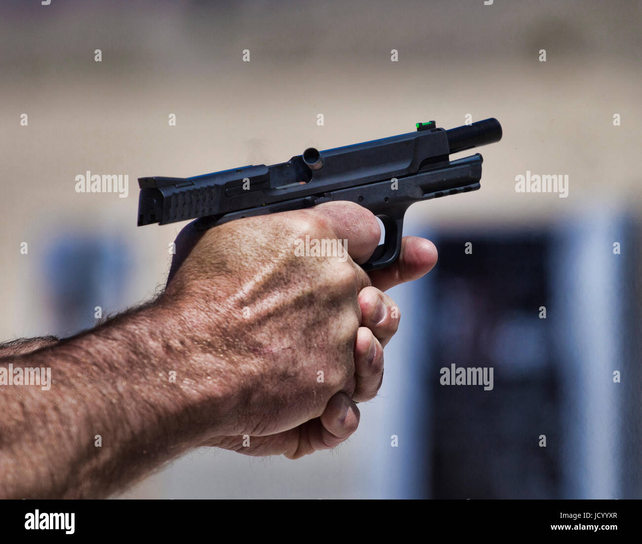 Pistole, die gerade gefeuert worden ist und ein leerer Koffer fliegen Stockfoto