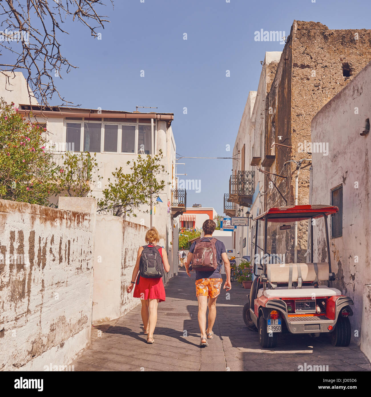 Äolischen Inseln, Stromboli, Sizilien, Italien, Juni 8 / 2016. Touristen gehen in einer Straße zu ihrem Recht typische lokale Auto. Stockfoto