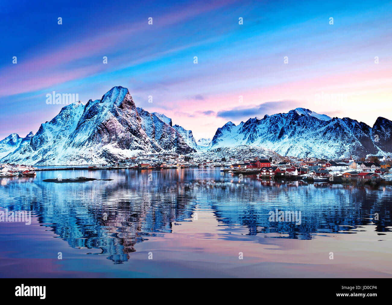 Mount Olstind spiegelt sich in den ruhigen Gewässern des Reinfjord auf den Lofoten-Inseln Stockfoto