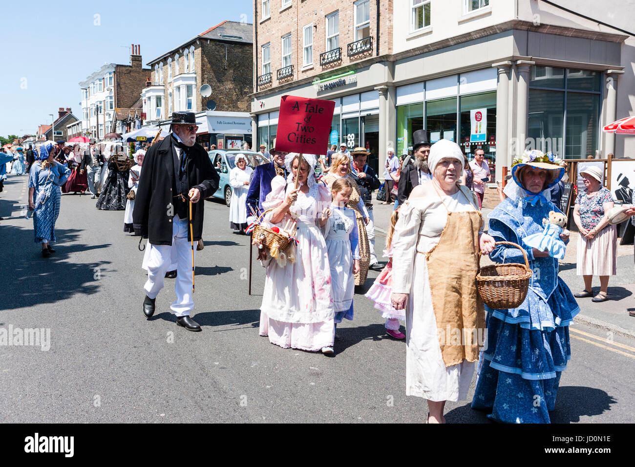 Broadstairs Dickens Woche Festival, dem wichtigsten Parade. Die Menschen gekleidet in viktorianischen Kostümen wie verschiedene Zeichen in Charles Dickens Romanen, Wandern entlang der High Street in strahlendem Sonnenschein. Stockfoto