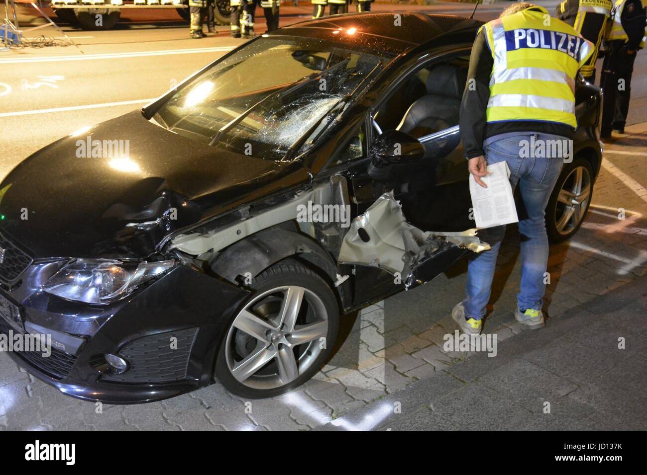 Dpatop - ein Polizist inspiziert das Autowrack an der Stelle des Vorfalls in Mönchengladbach, Deutschland, in den frühen Morgenstunden des Samstag, 17. Juni 2017. Ein Fußgänger wurde hier bei einem illegalen Autorennen in Thr Nacht des 16. Juni 2017 getötet. Nach einer Einweisung durch die Polizei wurden zwei Rennwagen durch die Innenstadt von Mönchengladbach. Eine 28-jährige verlor die Kontrolle über sein Fahrzeug und Fußgänger überfahren. Der Mann starb kurz darauf. Der Fahrer des zweiten Autos lief weg und war noch auf der Flucht am Morgen des 17. Juni. Foto: Stephan Schellhammer/dpa Stockfoto