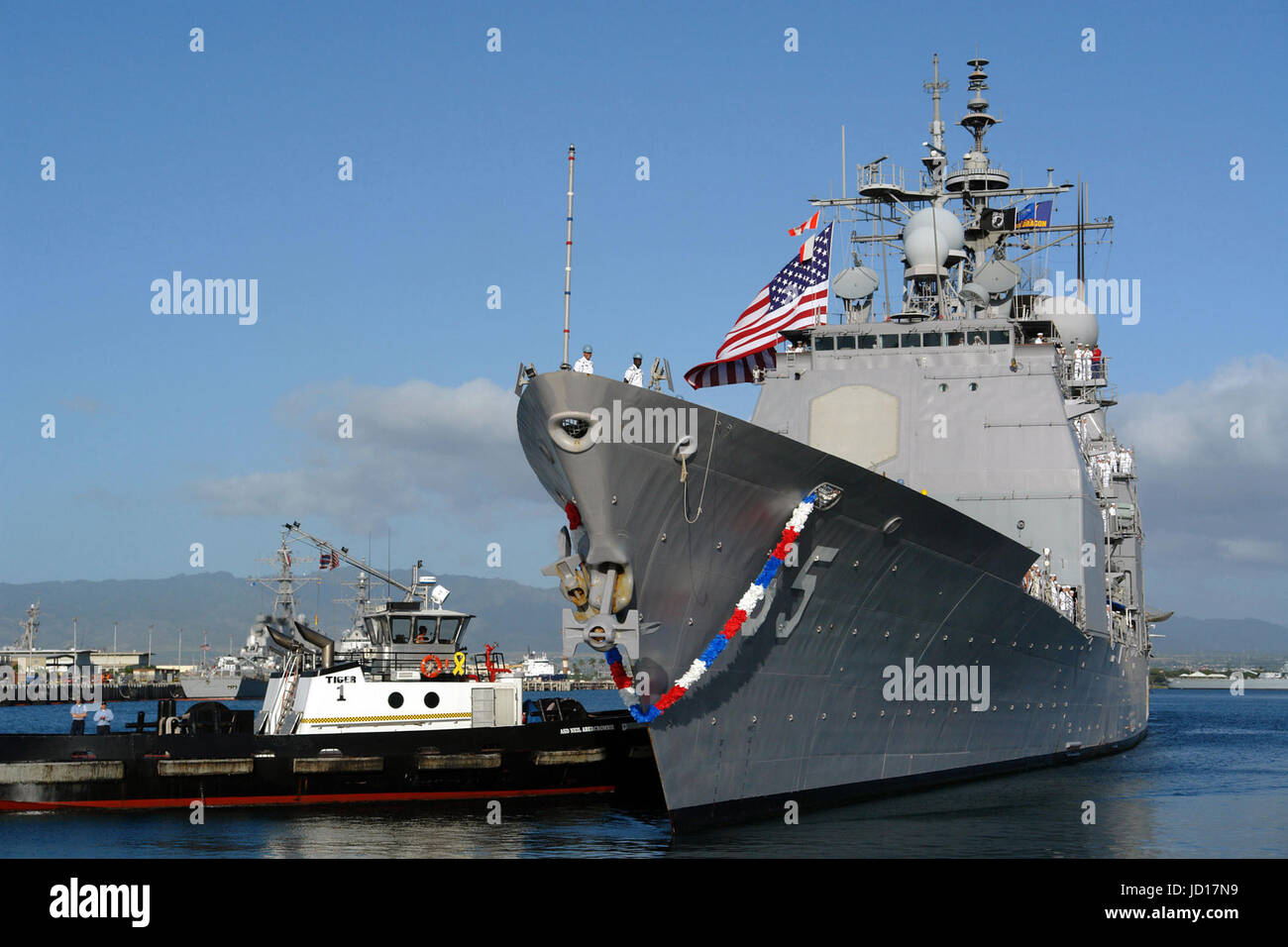 Schlepper drücken den Lenkwaffen-Kreuzer USS Chosin (CG-65) in Richtung Pier in Vorbereitung zum Festmachen in Pearl Harbor, Hawaii, DoD Foto von Chief Petty Officer Joe Kane, US Navy Stockfoto