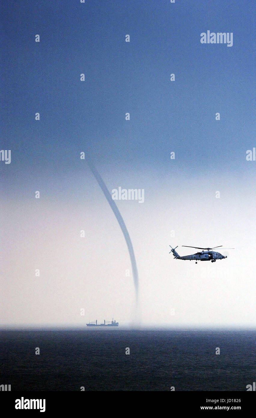Ein Marine HH - 60H Seahawk Hubschrauber hält ein Auge auf einem nahe gelegenen Behälter und eine Wasserhose während Patrouillen im Südchinesischen Meer vor der Küste von Malaysia. Foto: DoD Flieger Richard R. Waite, US Navy Stockfoto