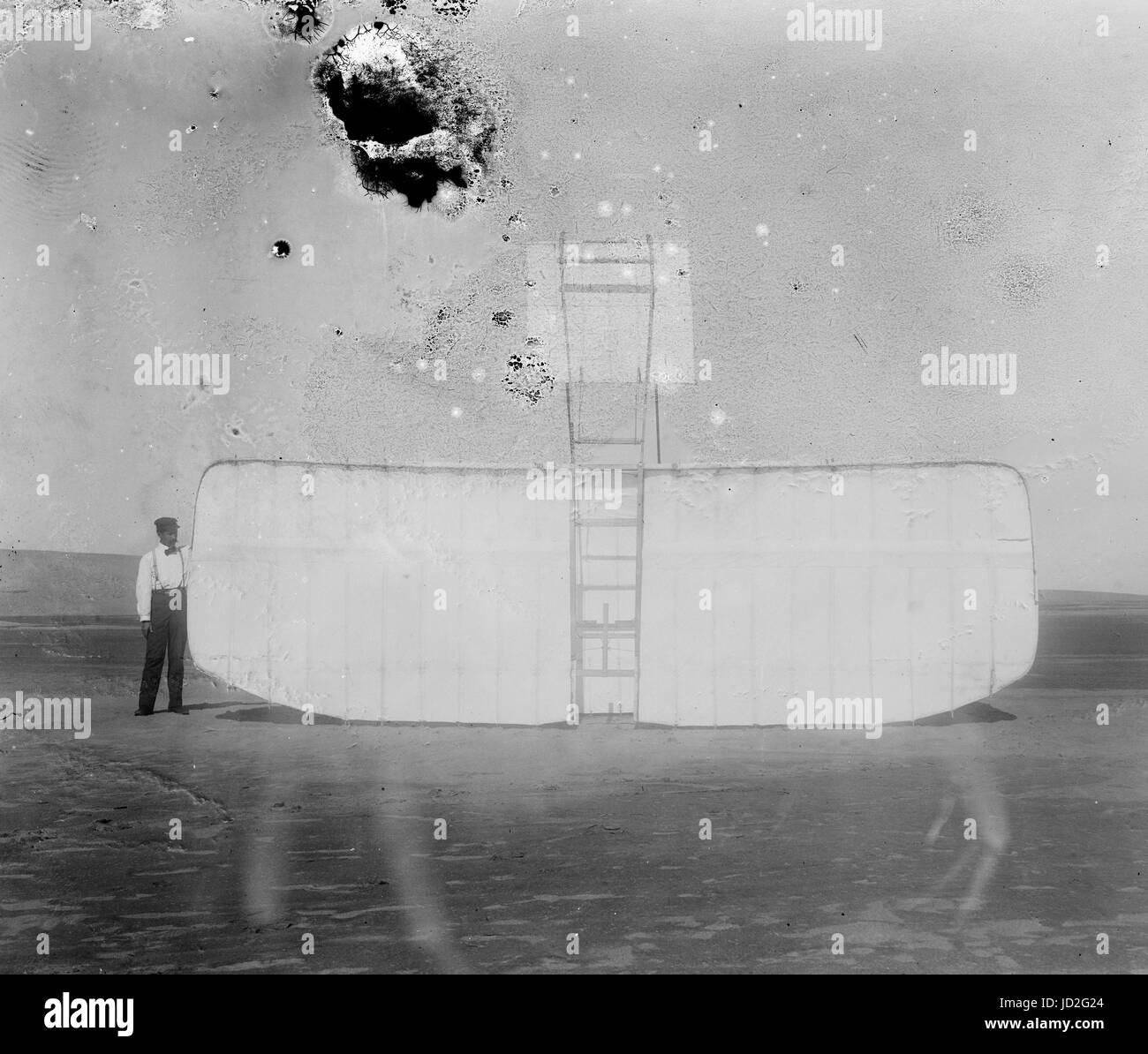 Orville am linken Flügel Ende des umgeworfenen Segelflugzeug, untere Ansicht; Kitty Hawk, North Carolina. Stockfoto