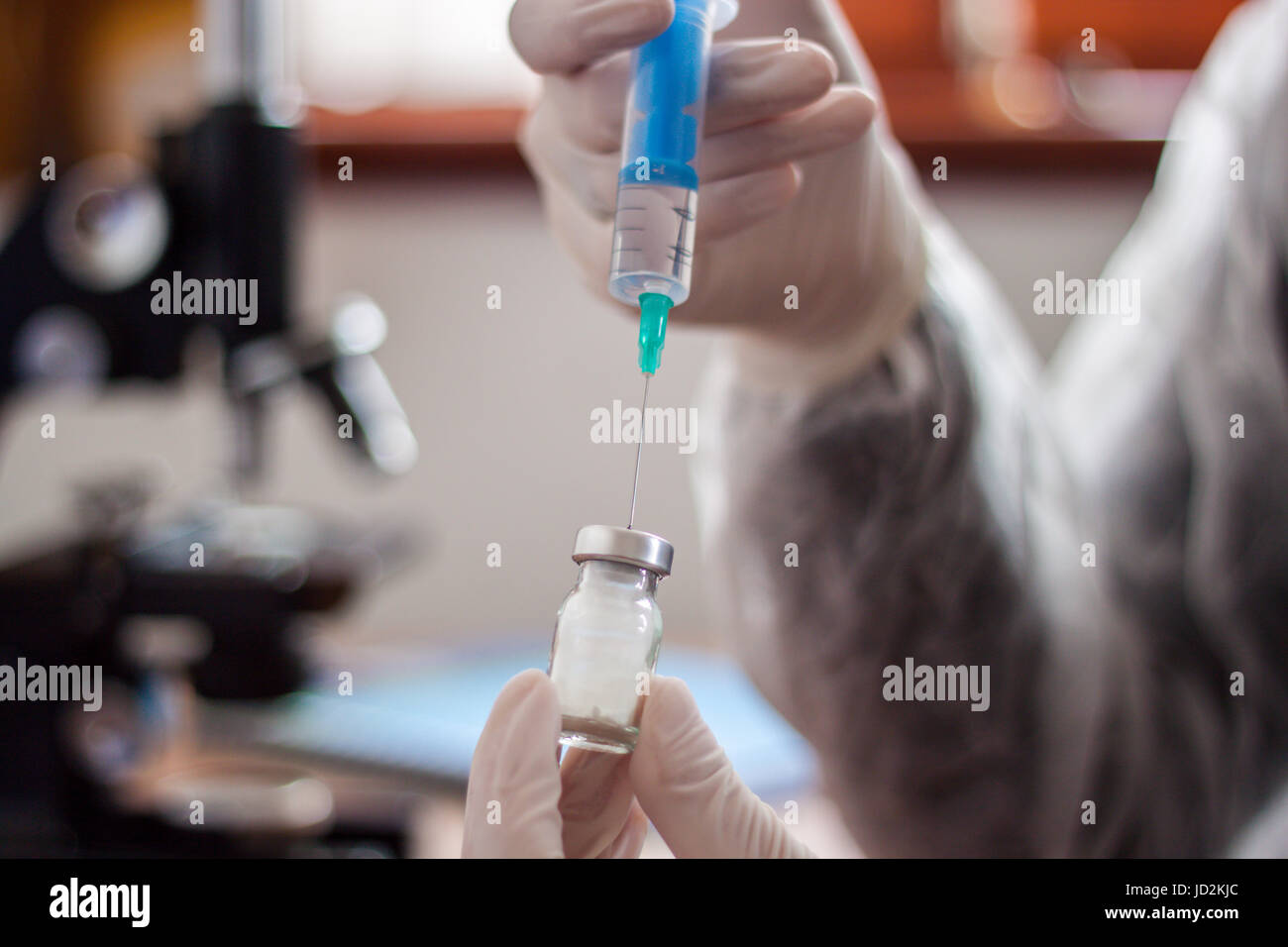 Junger Arzt bereitet eine Injektion zu einem Patienten, der injizierten Flüssigkeit in die Nadel halten sehr sorgfältig Stockfoto