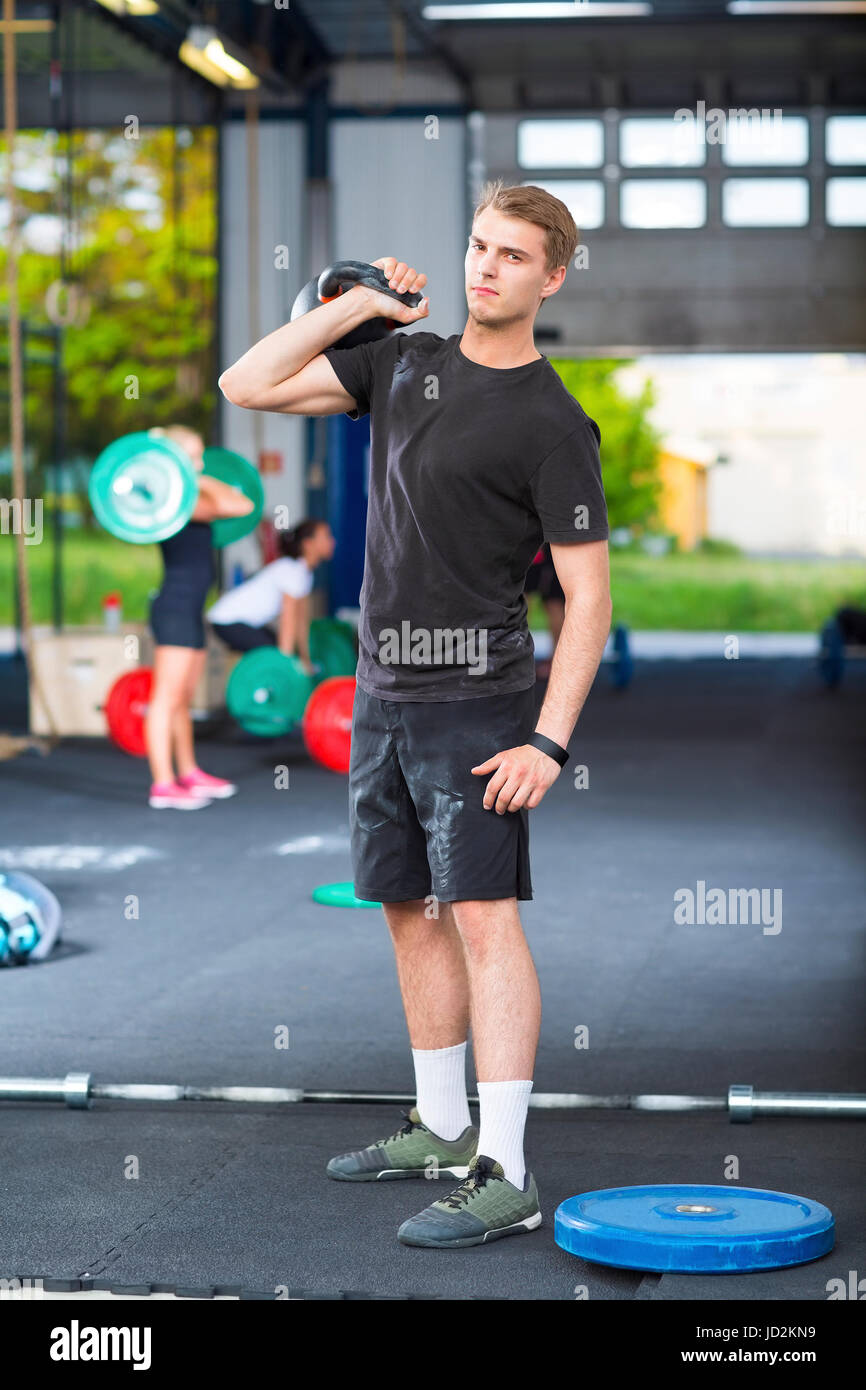 Zuversichtlich Sportler tragen Kettlebell im Health Club Stockfoto