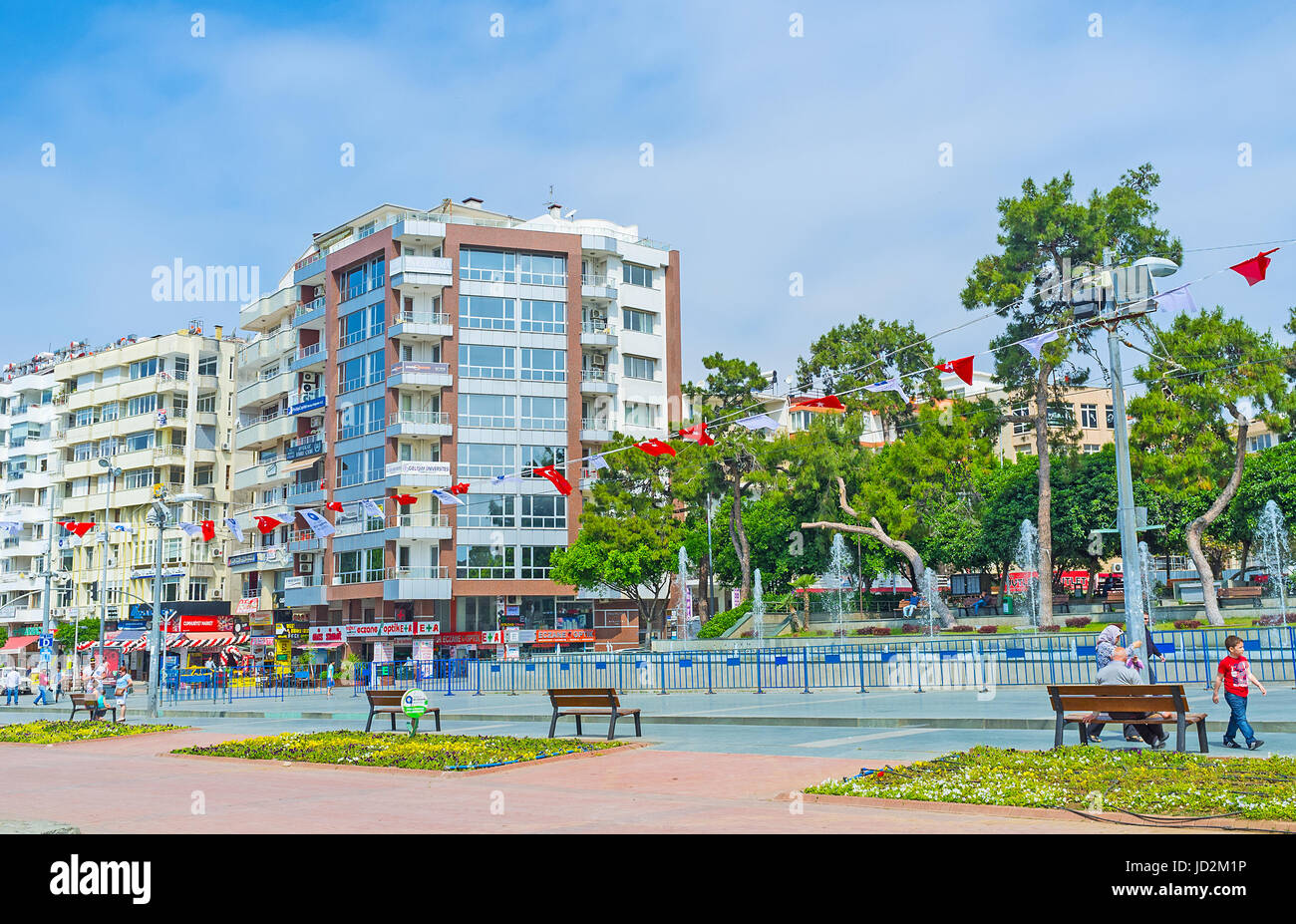 Antalya, Türkei - Mai 6, 2017: Republik Avenue (cumhuriyet cadessi) mit bunten Fahnen dekoriert, Menschen die Fontänen im Park genießen, sitzend auf der Stockfoto