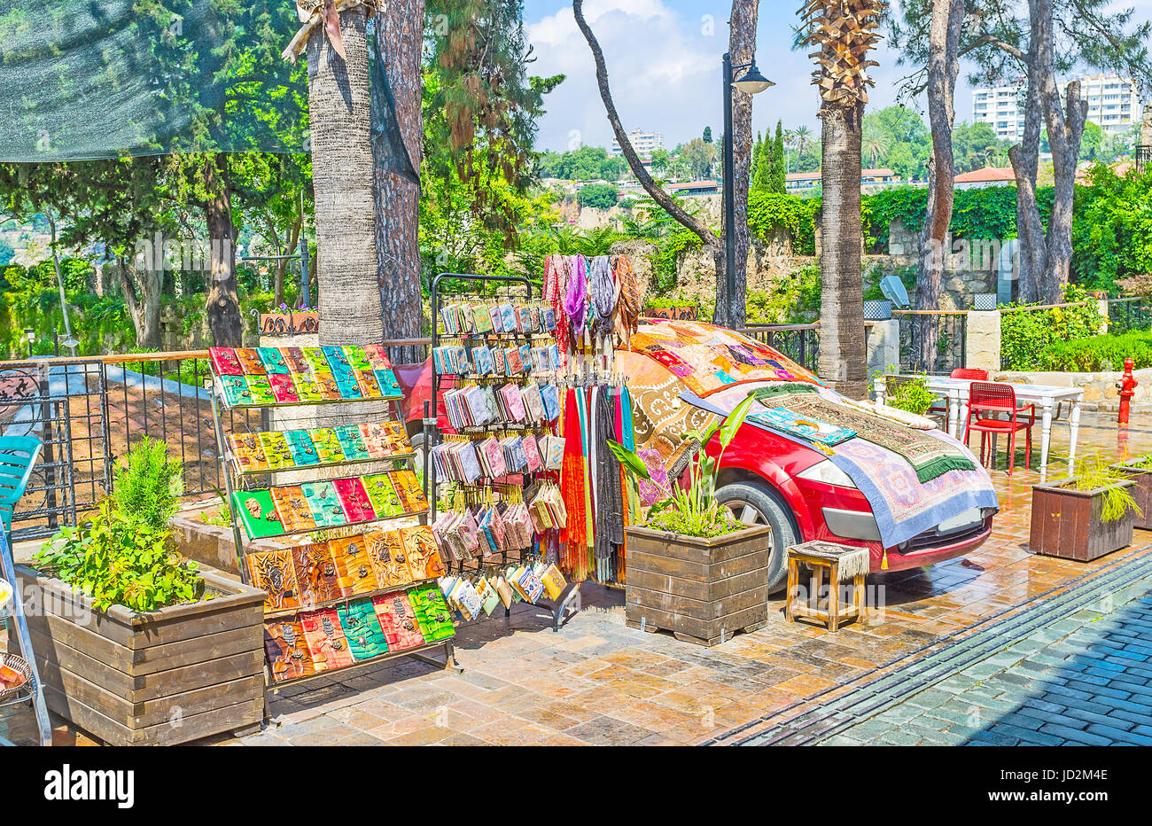 Die Racks mit bunten Souvenirs in der Straße, neben der Tourismuspark, die Teppiche und Wolldecken decken das Auto, Antalya, Türkei. Stockfoto