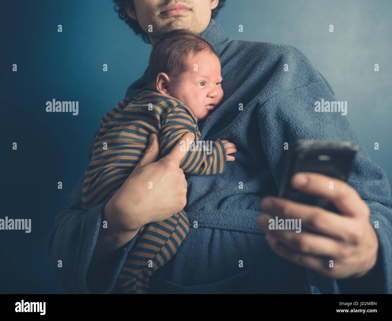 Ein junger Vater im Bademantel nimmt ein Selbstporträt mit seinem Baby Sohn Stockfoto