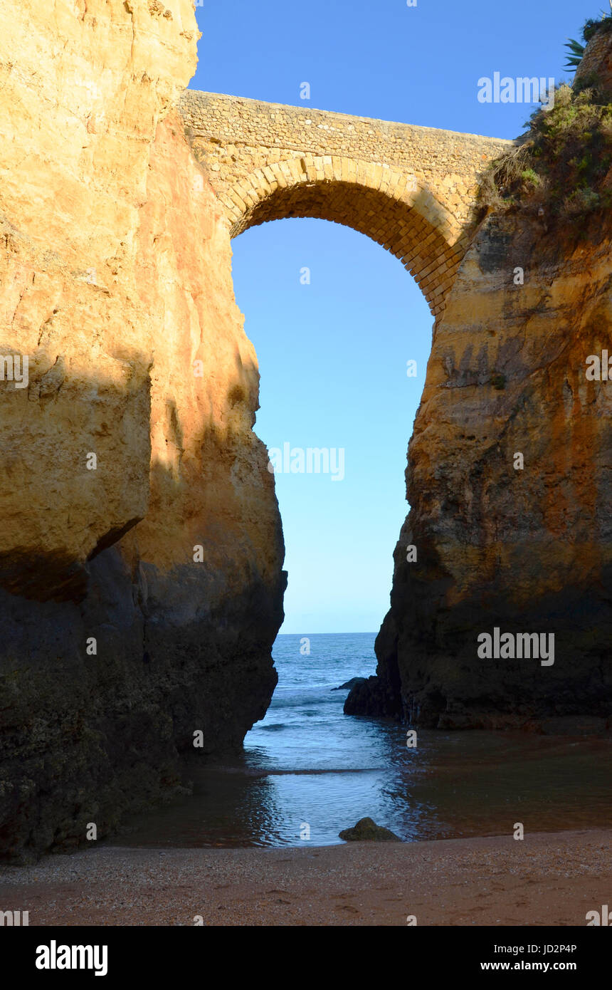 Brücke bei Lagos Strand (Praia da Batata), Algarve, Portugal während des Sonnenuntergangs Stockfoto