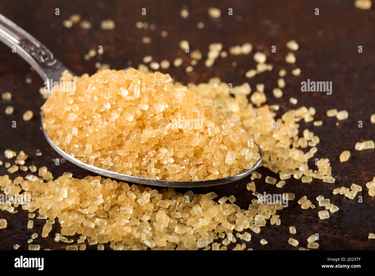 Nahaufnahme von braunem Zucker in einem Löffel auf dunklem Hintergrund Stockfoto