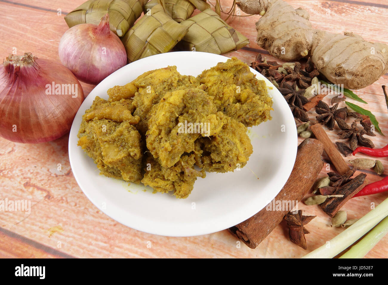 Malaysische Gericht Rendang Ayam oder trockene Curry Huhn und Ketupat Nasi (Reis Knödel) über hölzerne Hintergrund Stockfoto