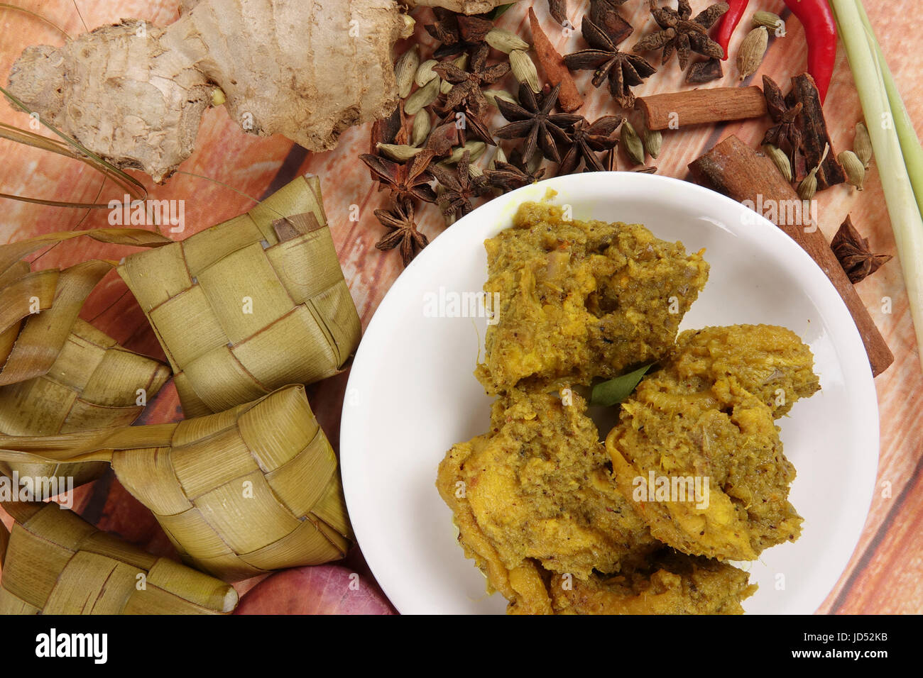 Malaysische Gericht Rendang Ayam oder trockene Curry Huhn und Ketupat Nasi (Reis Knödel) über hölzerne Hintergrund Stockfoto