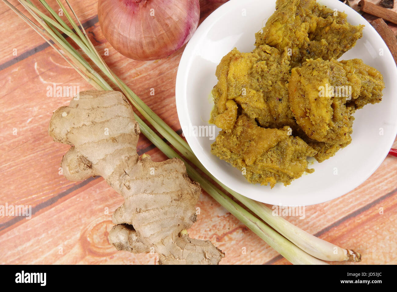 Malaysische Gericht Rendang Ayam oder trockene Curry Huhn und Ketupat Nasi (Reis Knödel) über hölzerne Hintergrund Stockfoto