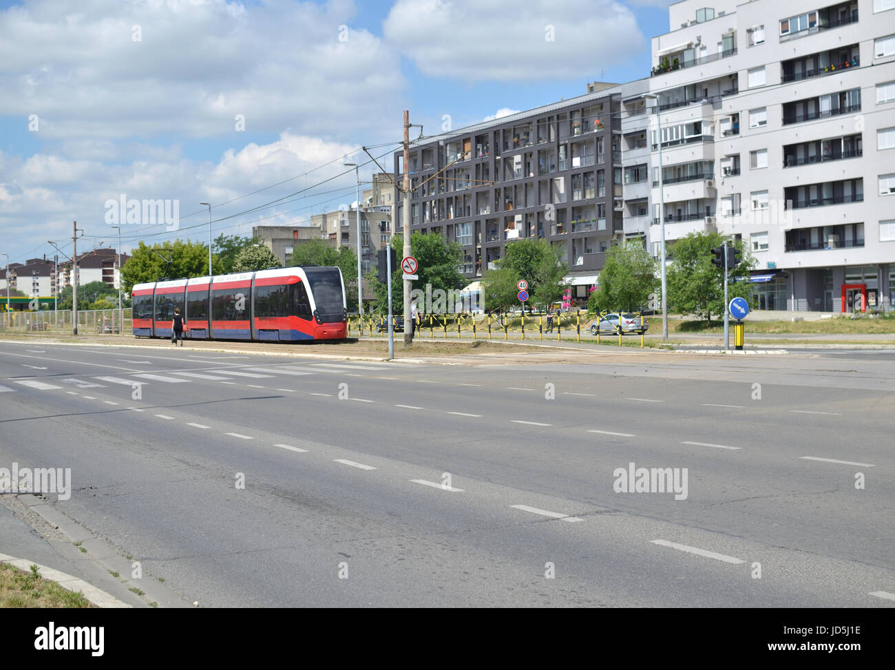 Rote Straßenbahn auf einem Boulevard im Wohngebiet von einer europäischen Stadt - Belgrad, Serbien Stockfoto
