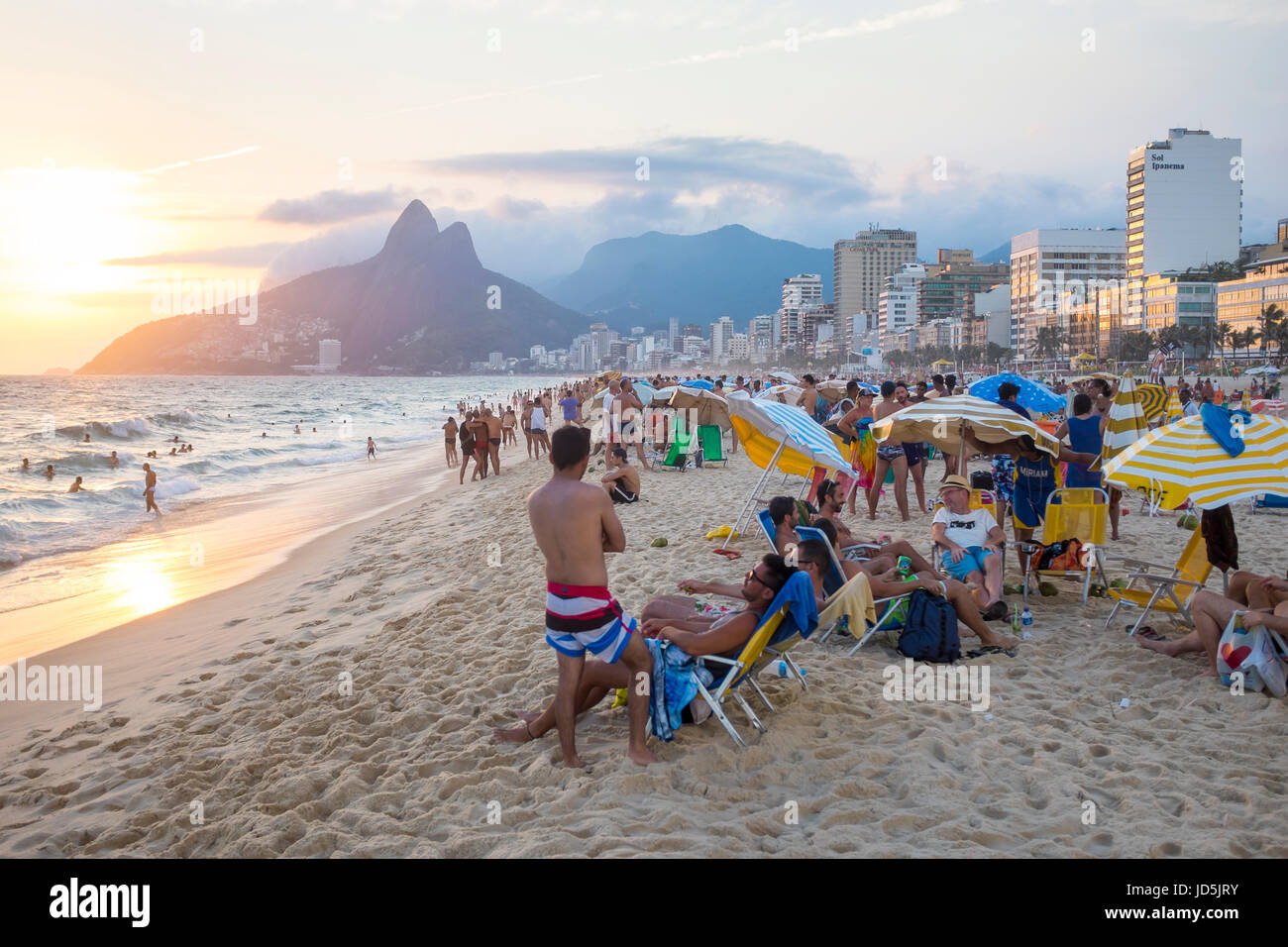 RIO DE JANEIRO - 27. Januar 2017: Strandbesucher am Strand von Ipanema lehnen Sie sich zurück in den Sonnenuntergang hinter zwei Brüder Berg nehmen. Stockfoto