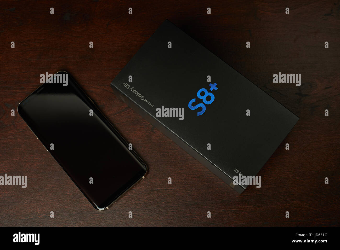 New York, USA - Juni 13, 2017:Samsung s8 plus Smartphone und Box lag auf dunklen braunen Holztisch Ansicht von oben Stockfoto