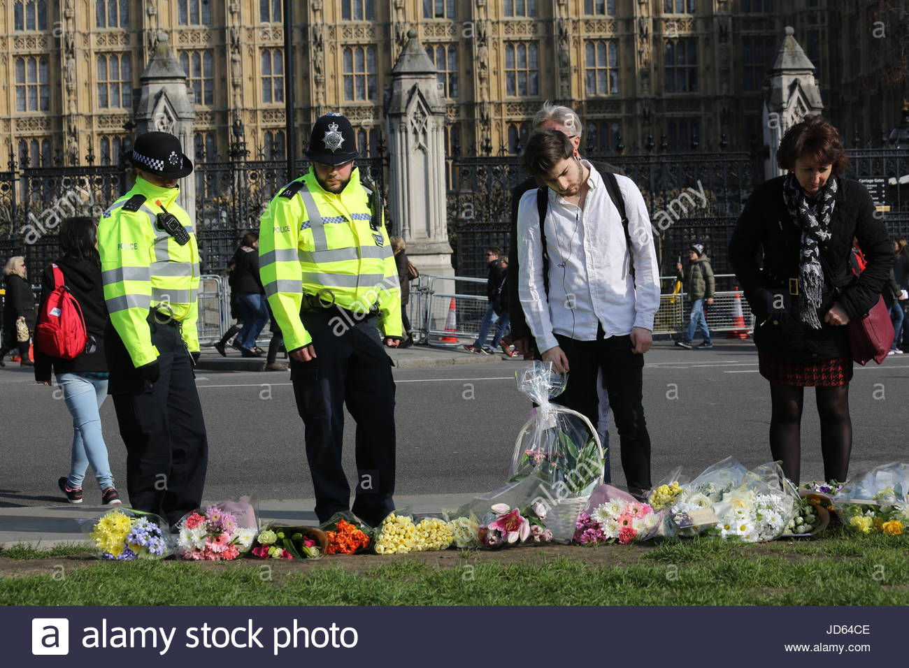 Polizisten und Mitglieder der Öffentlichkeit Blumen in Gedenken an PC Keith Palmer und die anderen Opfer des London-Terror-Anschlag dargelegt. Stockfoto