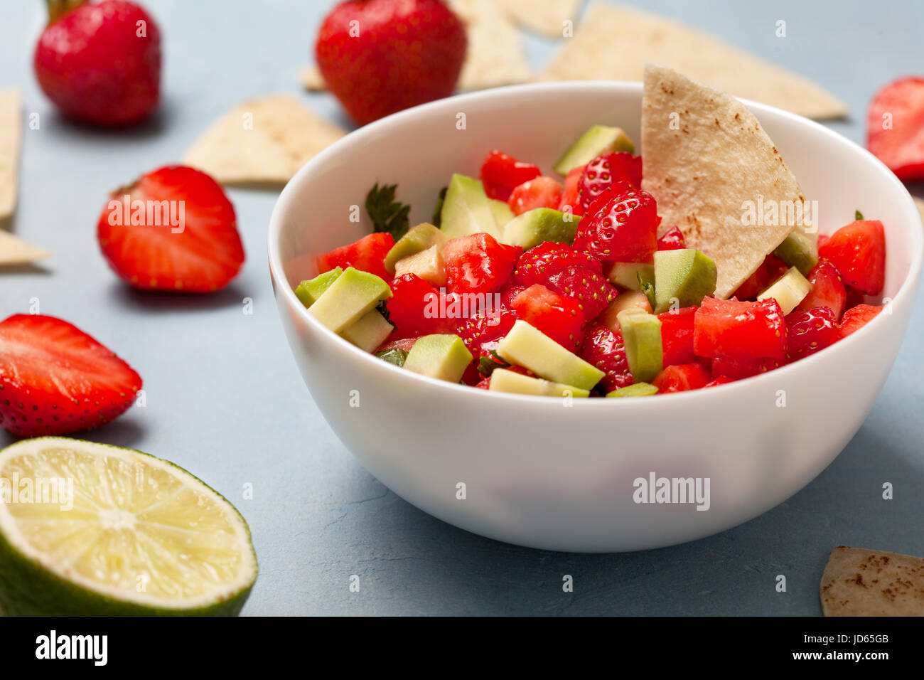 Salsa in Schüssel, frischen Erdbeere auf blauem Hintergrund Avocado Erdbeere Stockfoto