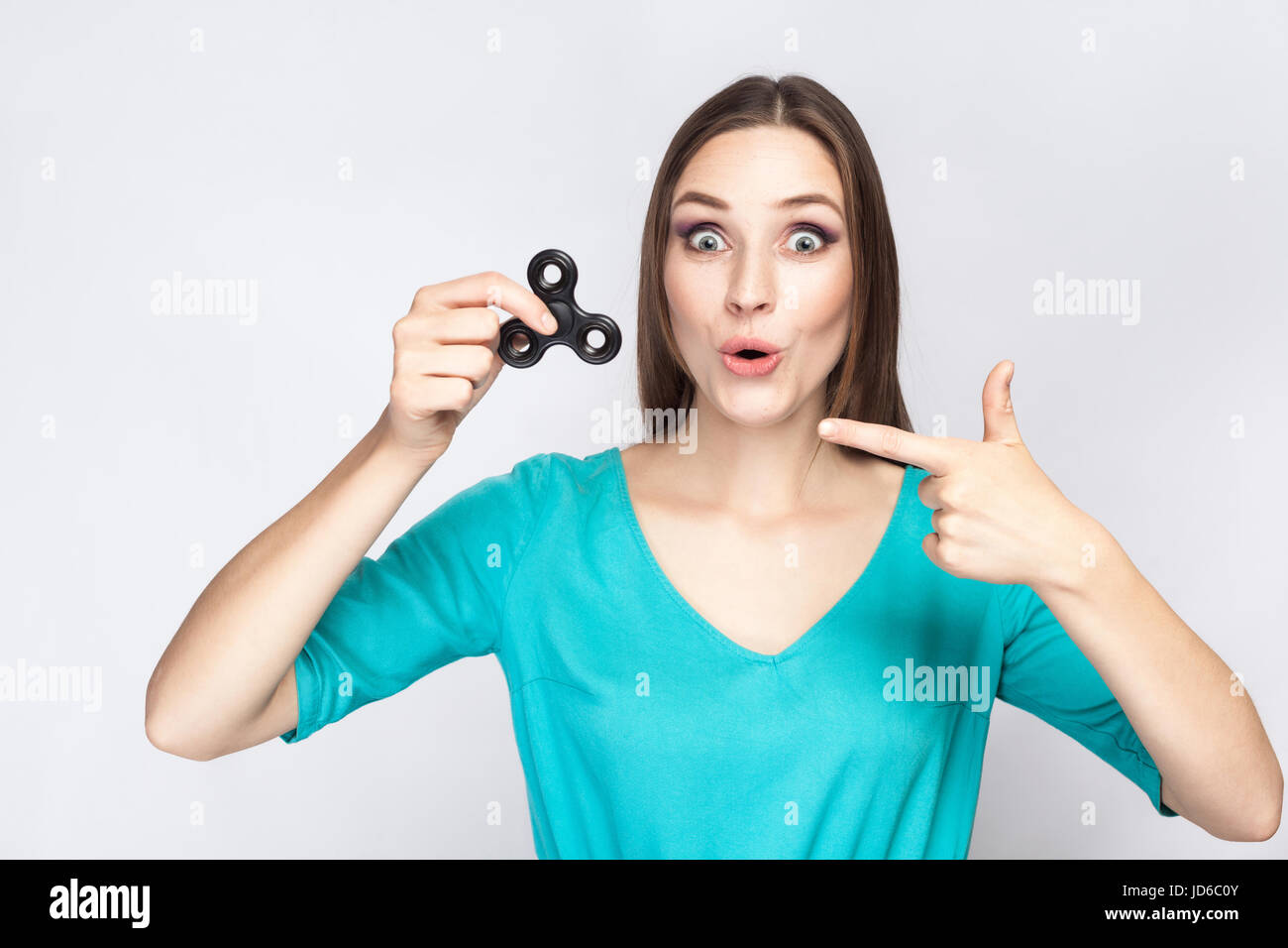 Junge schöne Mädchen halten und spielen mit Fidget Spinner. Studio auf weißem Hintergrund gedreht. Stockfoto