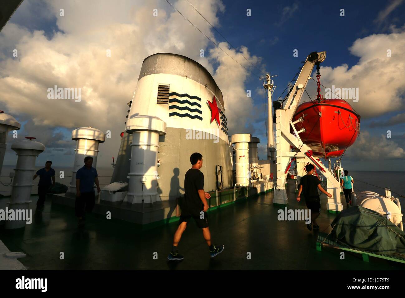 (170619)--an Bord XIANGYANGHONG 09, 19. Juni 2017 (Xinhua)--Foto am 18. Juni 2017 zeigt Crew-Mitglieder, die zu Fuß auf dem Deck des Xiangyanghong 09, Mutterschiff von Chinas bemannte Tauchpumpe Jiaolong wie Sonnenuntergang Landschaft im Westen Pazifik gesehen wird. (Xinhua/Liu Shiping) (Angeles) Stockfoto