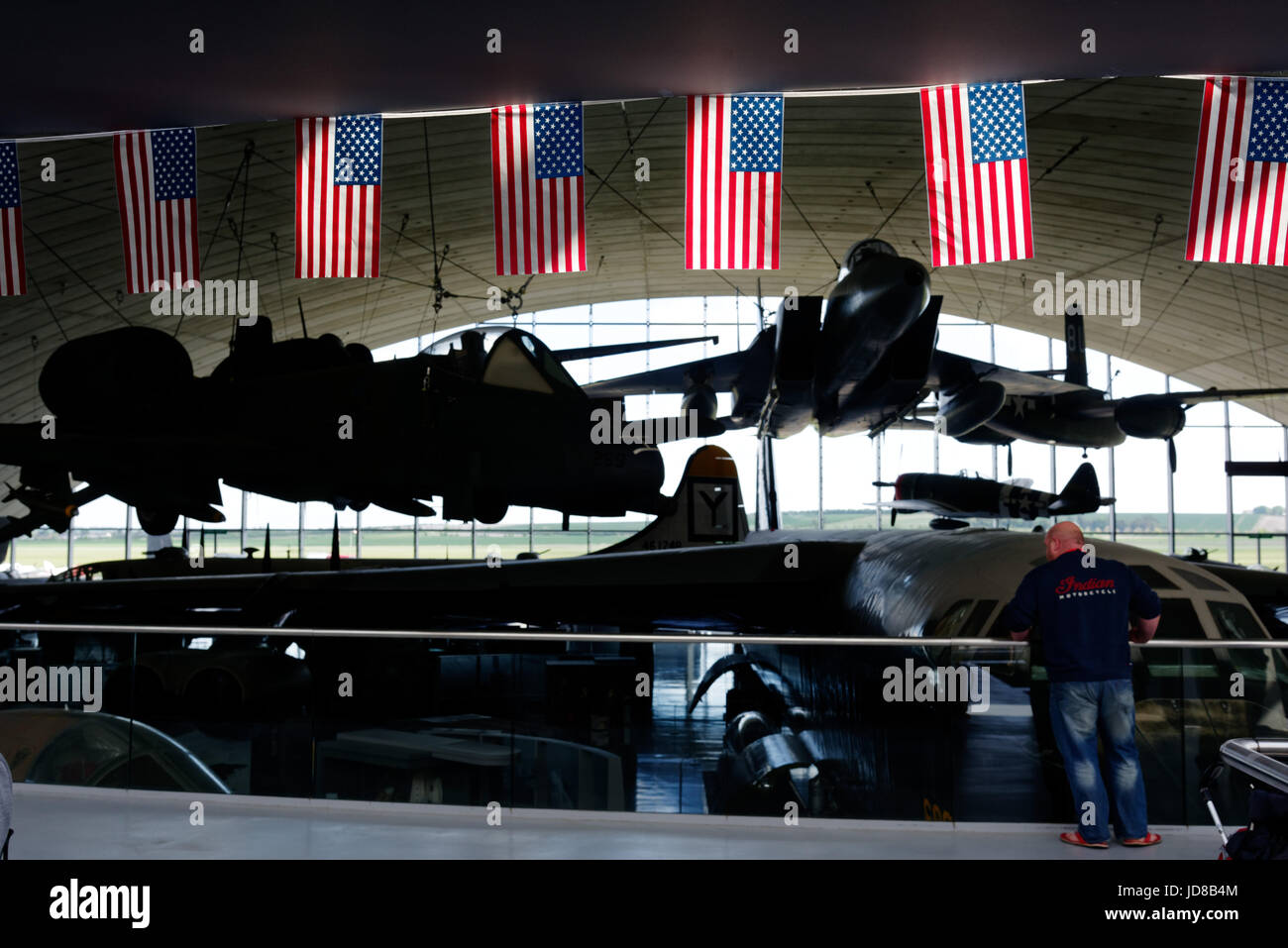 Duxford Air Museum in Cambridgeshie, England. Die Sonne leuchtet die Stars & Stripes im American Air Museum mit der F-15 Eagle darüber hinaus. Stockfoto