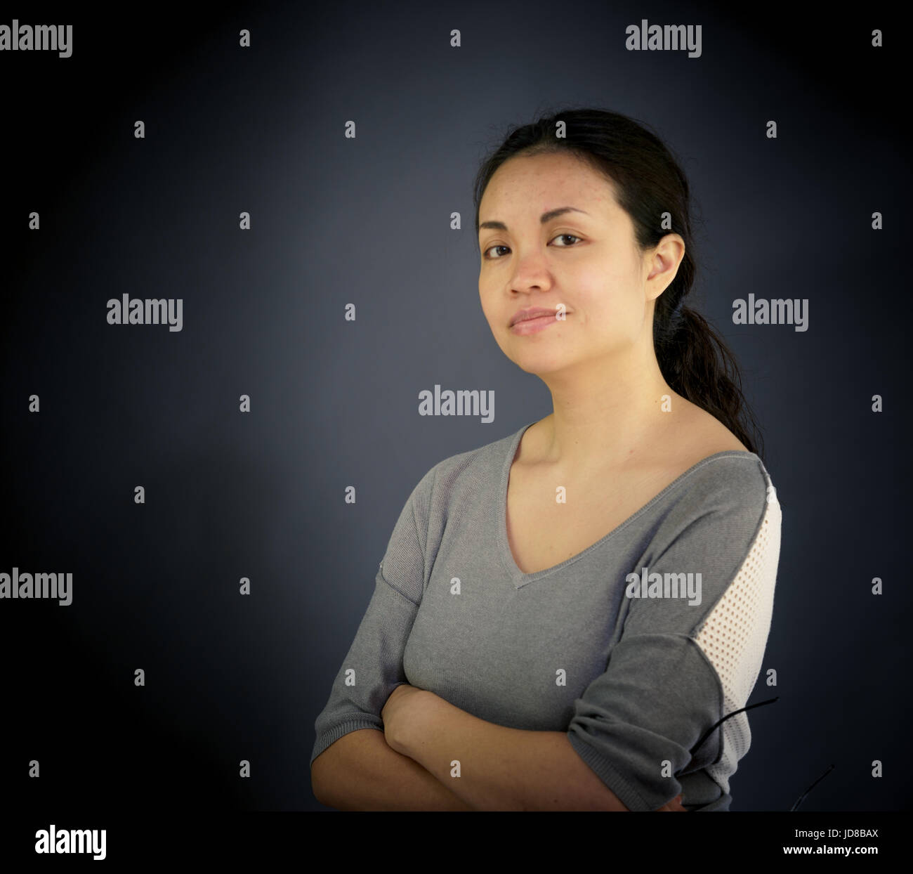 Porträt der Frau Blick in die Kamera, Studio gedreht, einfarbigen Hintergrund. asiatisch, lange Haare, Erwachsene Stockfoto