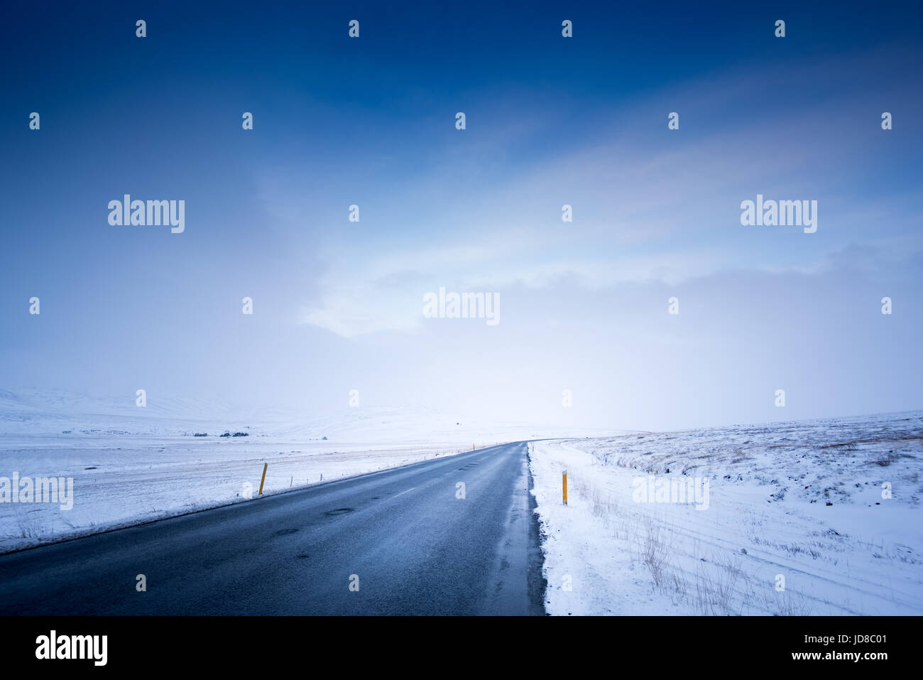 Düstere Schneelandschaft, Straßen- und stürmischen Himmel bei Tag, Island, Europa. Island-Natur 2017 Winterkälte Stockfoto