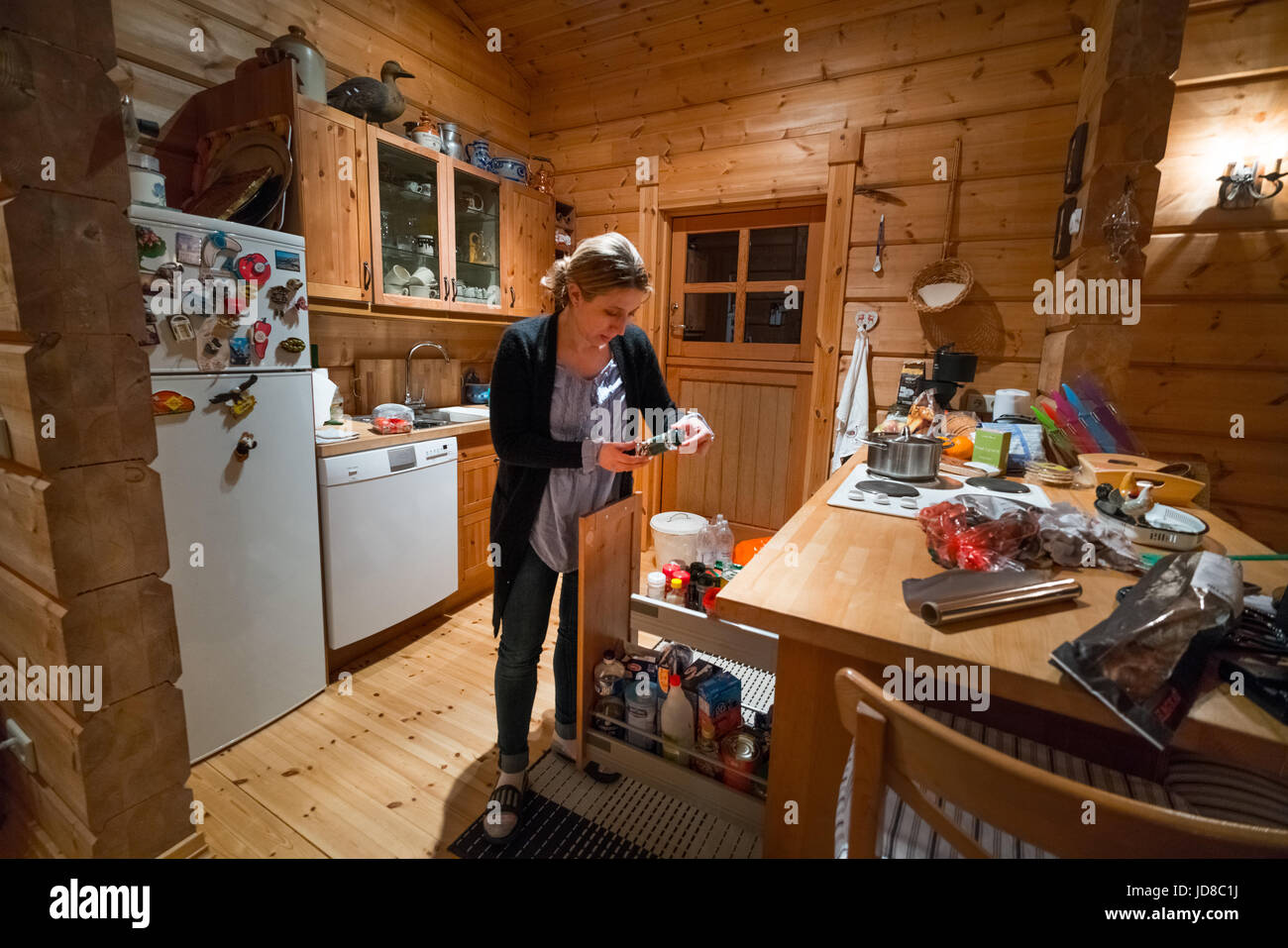 Frau stehend in der Küche der Blockhütte Blick auf Lebensmittel, Island, Europa. Island-Natur 2017 Winterkälte Stockfoto