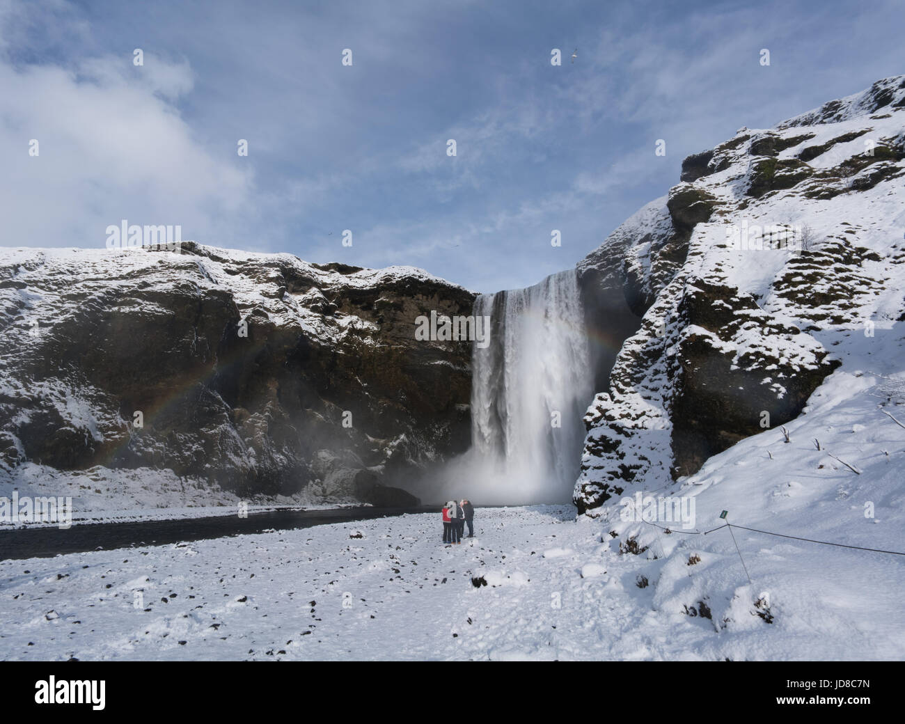 Touristen Anzeigen von Schnee bedeckte Landschaft und hohen Wasserfall, Island, Europa. Island-Natur 2017 Winterkälte Stockfoto