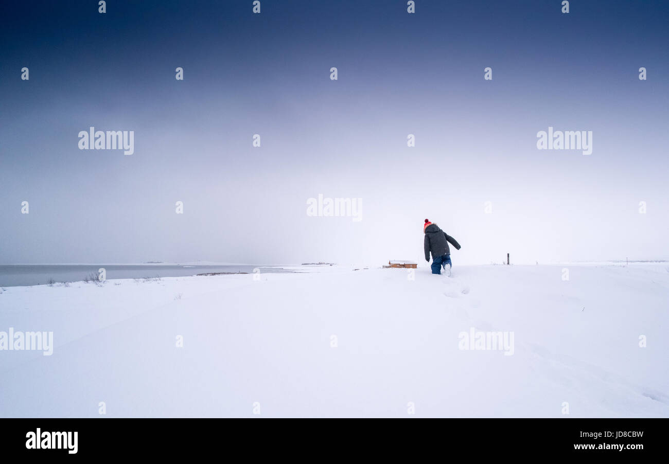 Kleiner Junge spielt in tief verschneite Landschaft, Island, Europa. Island-Natur 2017 Winterkälte Stockfoto