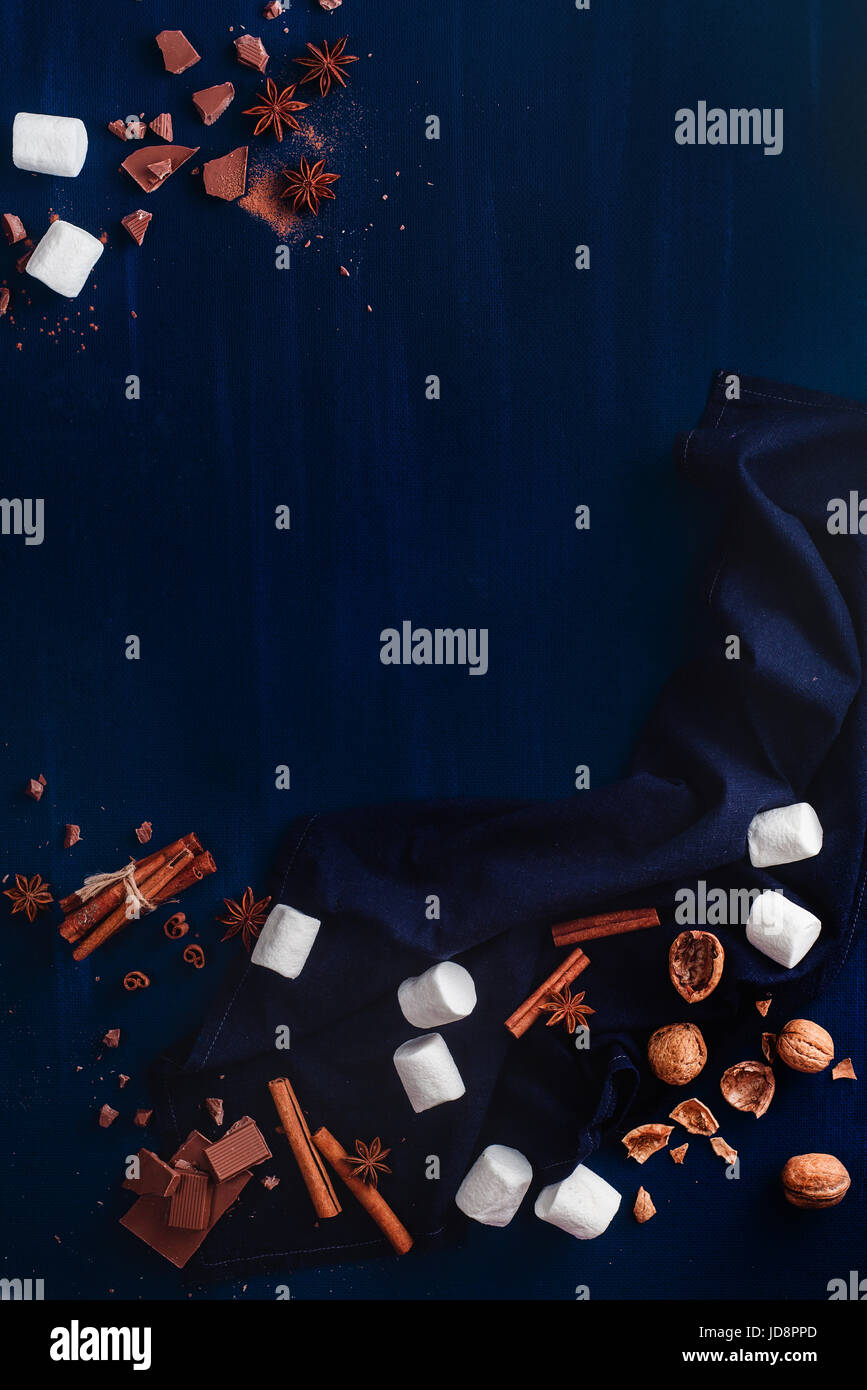 Dunkle Kopie Gitterrohrrahmen mit Süßigkeiten: Marshmallows, Walnüsse, Schokolade, Kakaopulver und Zimt auf schwarzem Hintergrund Stockfoto