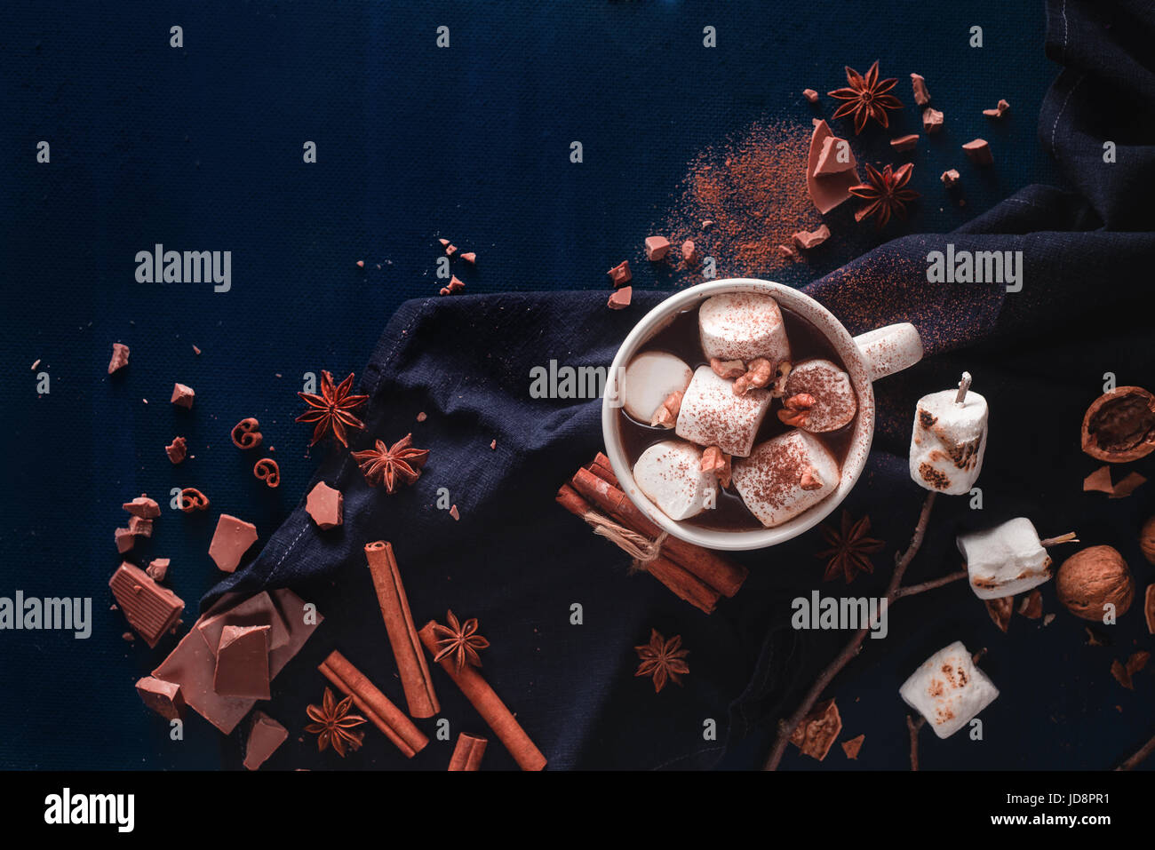 Eine Tasse heiße Schokolade mit Zimt, Marshmallows und Walnüsse auf einem dunklen Hintergrund mit Textfreiraum Stockfoto