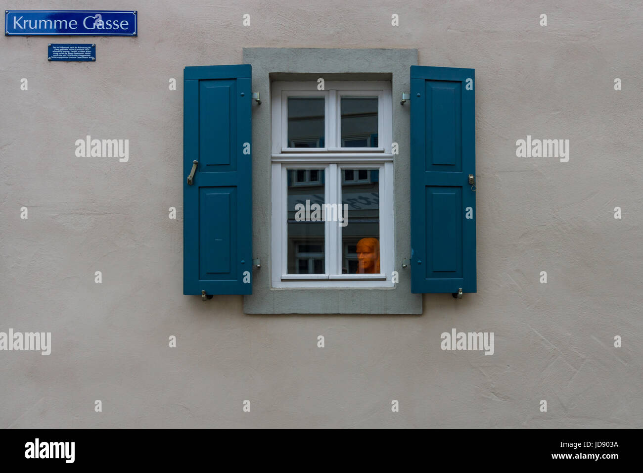 Eine ungewöhnliche orange Büste im Fenster, auf einer alten Straße im Zentrum der Stadt. Schweinfurt - eine mittelalterliche Stadt im Jahr 761 gegründet. Stockfoto