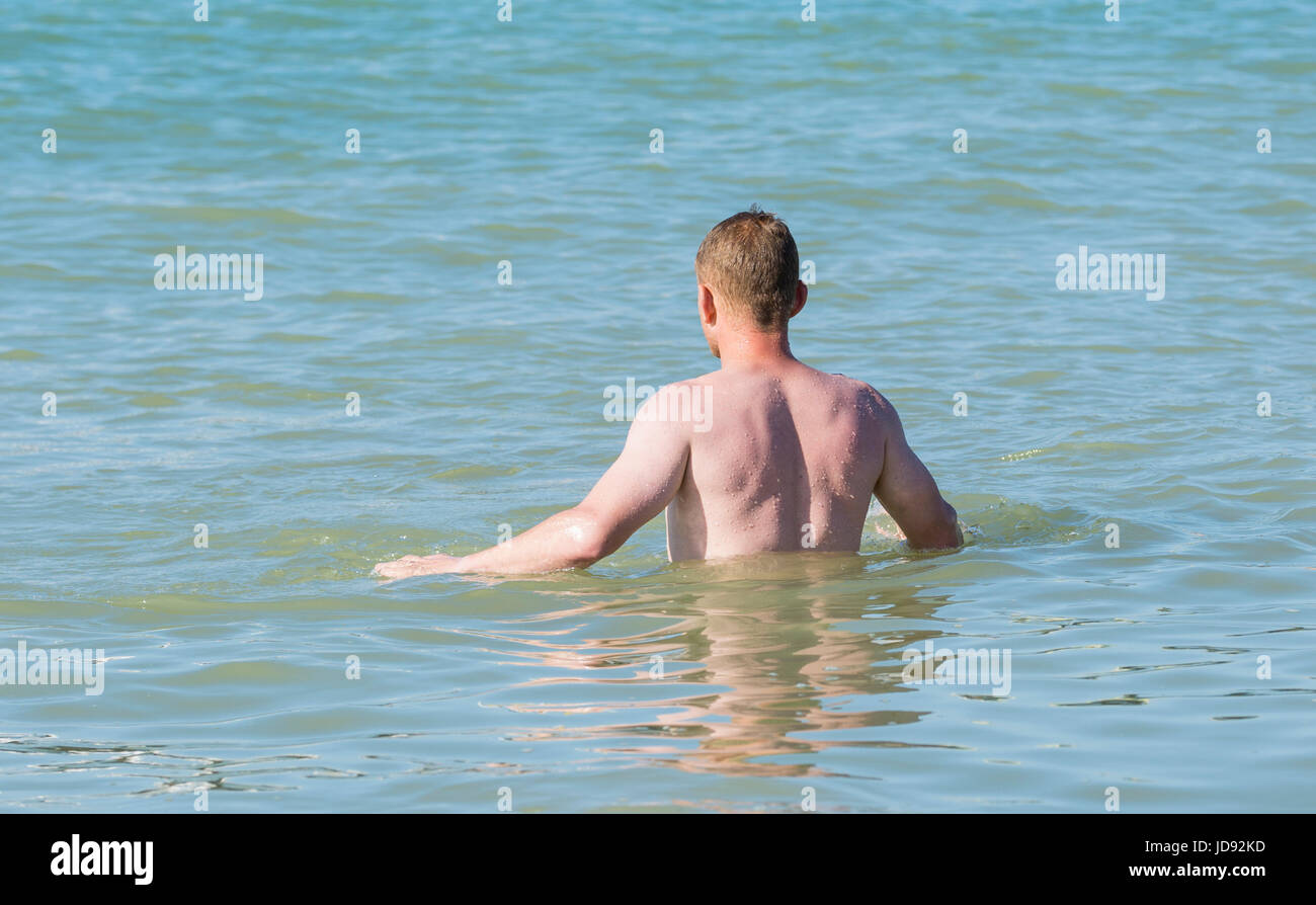 Schwimmen im Meer. Ein junger Mann nimmt ein Swin im Meer an einem sonnigen Morgen sehr Hgt. Stockfoto