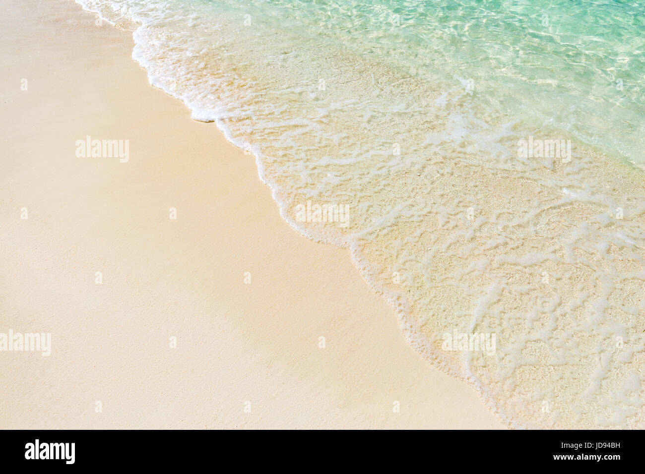 Schöner Strand mit sanften Wellen und kristallklarem Wasser entspannen Stockfoto