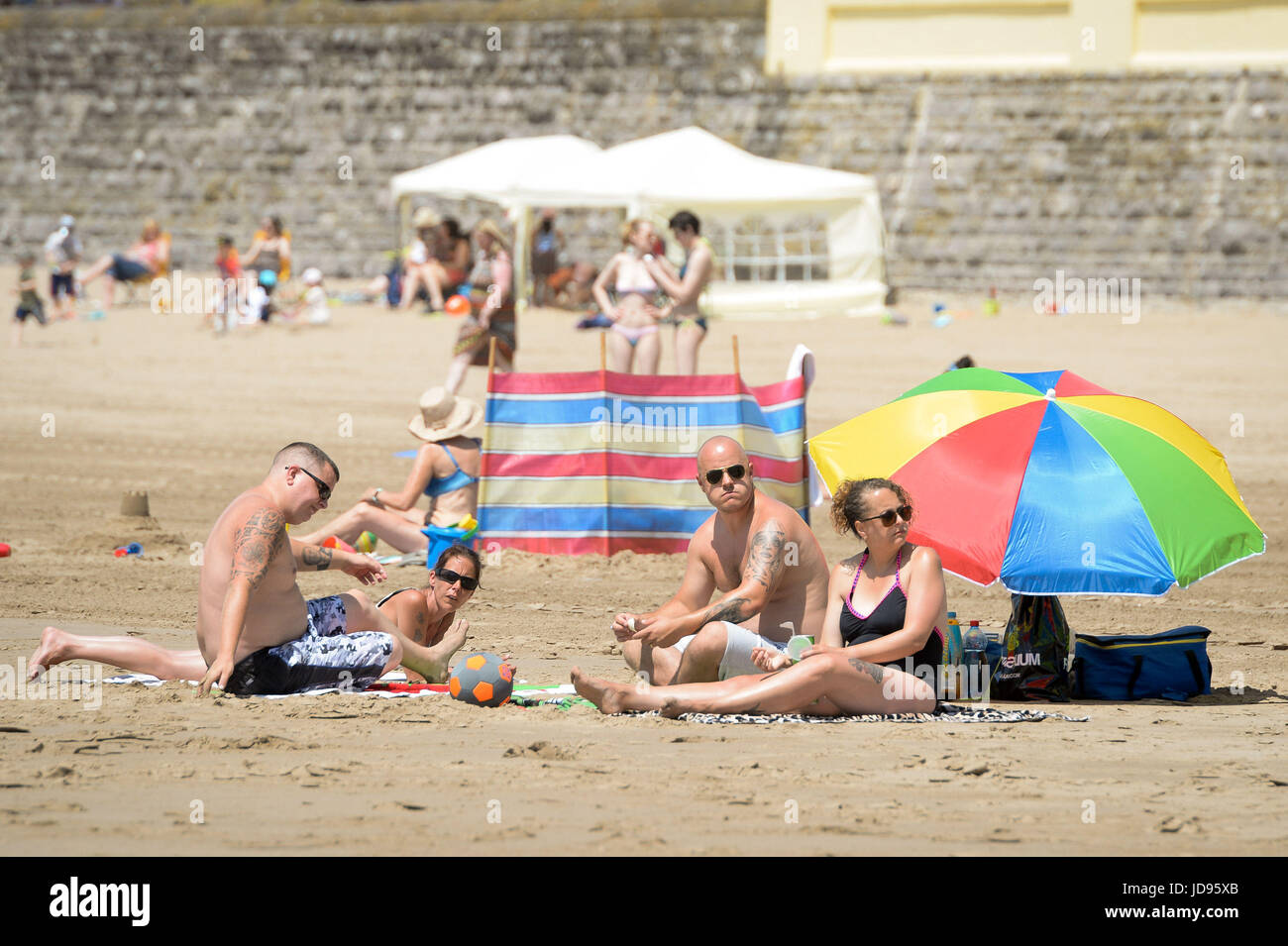 Sonnenanbeter am Strand von Barry Island, South Wales, wo Temperaturen in den hohen zwanziger Jahren sind und Menschen strömen in das Meer, das herrliche sonnige Wetter zu genießen. Stockfoto