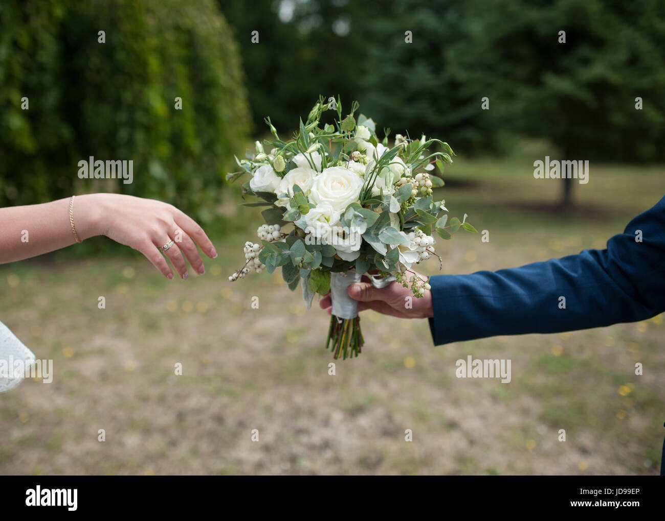 Bräutigam gibt der Braut eine schöne Hochzeit Bouquet. Stockfoto