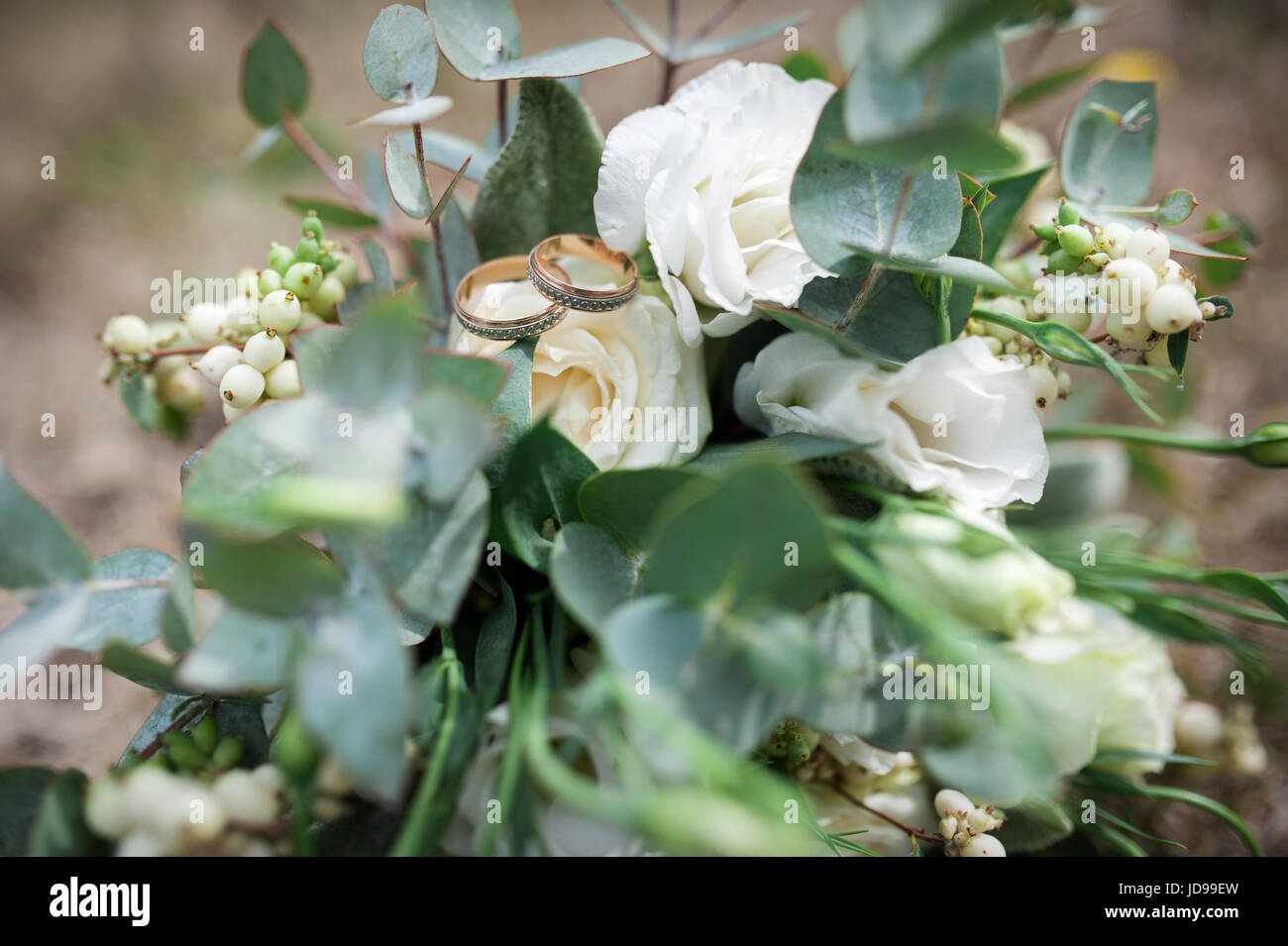 Schöne Trauringe auf einem weißen Bouquet. Stockfoto