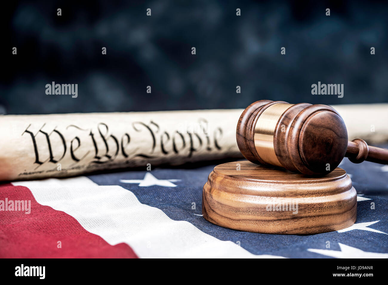 Verfassung der Vereinigten Staaten auf eine amerikanische Flagge mit einem Hammer im Vordergrund aufgerollt. Raum für Kopie entlang der oberen Hälfte des Bildes. Stockfoto