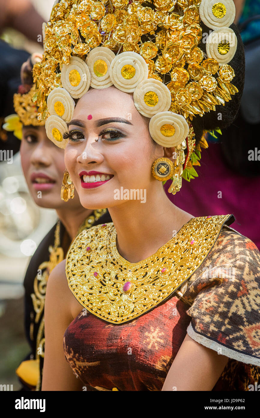 Elegante Porträt einer schönen balinesische Frau in extravaganten Bali Tracht gekleidet und lächelt in die Kamera. Atemberaubende goldene Kopfschmuck Stockfoto