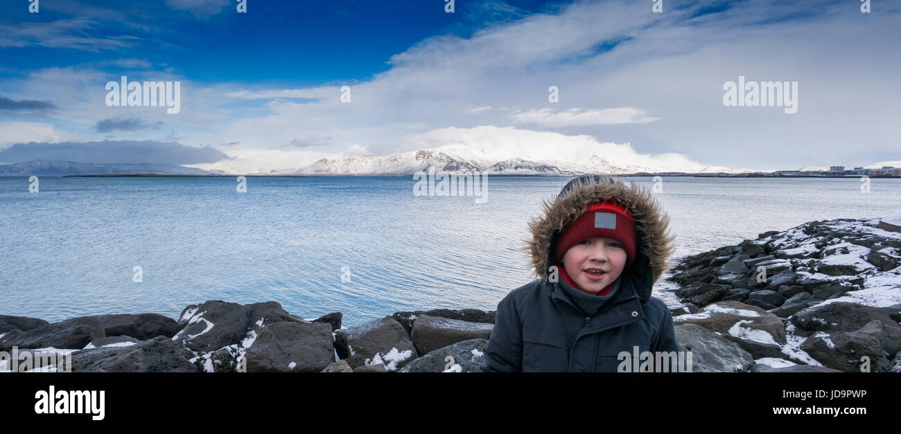 Porträt eines jungen Jungen mit Meer hinter und blauer Himmel, Island, Europa. Island-Natur 2017 Winterkälte Stockfoto