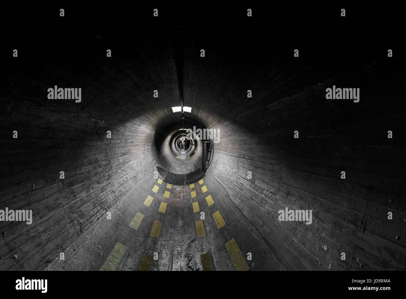 Blick durch dunklen grauen Tunnel mit abnehmender Perspektive und unheimliche Beleuchtung. Stockfoto